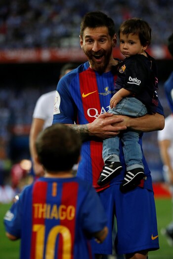 La sonrisa de Lionel: con Thiago mirando y Mateo en sus brazos (Reuters)