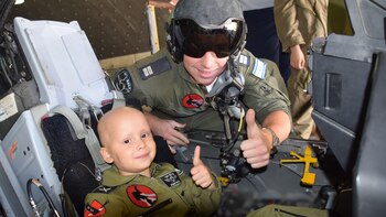 Un niño saluda junto a