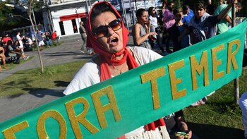 Una manifestante sostiene un cartel