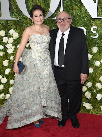 La actriz Lucy DeVito lució un vestido sin mangas en tonos grises con transparencias y llegó a la alofmbra roja junto a su padre, Danny DeVito