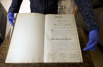 Yolaine Toussaint abre los Estatutos del Banco de Montreal, con más de 200 años de historia (Bloomberg / Christinne Muschi)