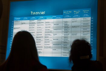 Dos personas del público consultan la cartelera de actividades de La Noche de la Filosofía