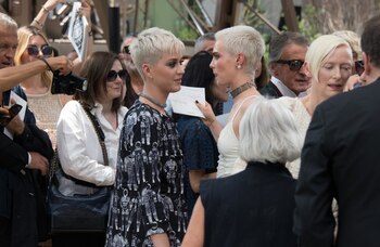 Katy Perry conversa tras bambalinas del desfile de Chanel con Cara Delevigne. A su derecha la actriz Tilda Swinton, una abanderada del look “garçon” por años. Foto AP