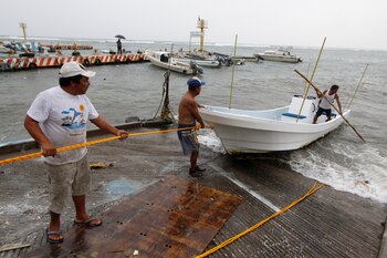 Un grupo de pescadores sacan un bote del mar en Veracruz (REUTERS/Victor Yanez)