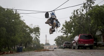 Zapatillas cuelgan de un cable de luz caído por las tormentas del huracán Harvey en Corpus Christi, Texas (AP)