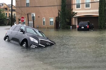 Dos vehículos atrapados por las inundaciones (Reuters)