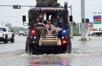 Una mujer es evacuada por las autoridades (Reuters)