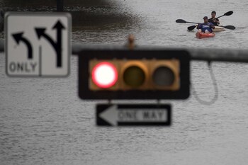 Dos hombres transitan una calle en kayak (Reuters)