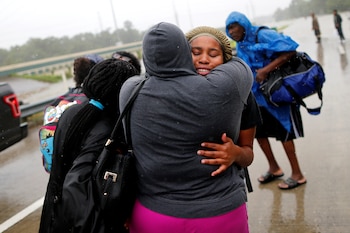 Una mujer es abrazada por una amiga tras ser rescatada en Beaumont Place, Houston (Reuters)