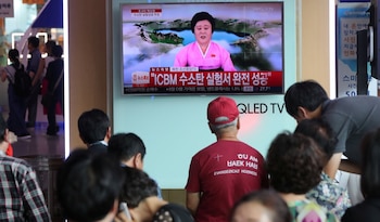 Norcoreanos observan por la televisión