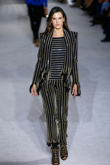 Alessandra Ambrosio, la top model de Victoria’s Secret, subió a la pasarela de Balmain. Rayas verticales y horizontales de cadenas doradas sobre pantalón, camisa y blazer fue su pasada