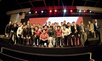 El plantel casi completo (faltaban los convocados a las Eliminatorias) junto a un grupo de juveniles en el escenario.