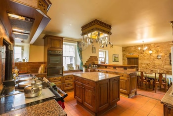 La cocina rústica con alacenas en madera pero con electrodomésticos de última generación (Airbnb)