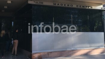 El frente de la puerta principal de acceso a Madero Center, en el vidrio se puede ver el reflejo de la camioneta de Prefectura