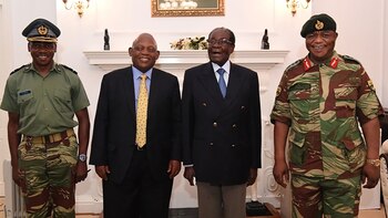 El presidente Robert Mugabe posa rodeado de el comandante de las Fuerzas de defensa de Zimbabwe Gral. Constantino Chiwenga y un enviado de Sudáfrica en la Casa de Gobierno de Harare (AFP)