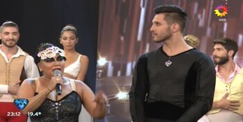 Facundo Arrigoni, el bailarín de La Bomba, mira hacia un costado mientras la cantante discute con su coach