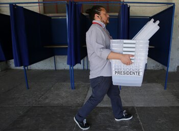 Un empleado carga urnas en