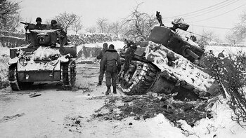 Contar las péridas y contraatacar. Un tanque ligero estadounidense M3 Stuart avanza junto a un M4 Sherman destruido por los alemanes