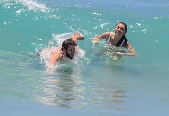 Ella, al principio entró tímidamente, pero él, salpicándola y haciendo piruetas en el agua, consiguió que termine chapoteando junto a él.