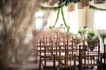 La ceremonia se realizó en un salón decorado con cortinas de guipure y guirnaldas de follaje.
