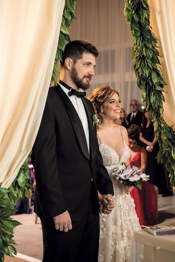 Los novios fueron asesorados por Bernie Catoira. Dalma lució un vestido en tono off white de la diseñadora israelí Berta, con flores aplicadas en relieve en la falda y breteles de cristales. Andrés, un smoking negro de líneas clásicas de Hugo Boss.