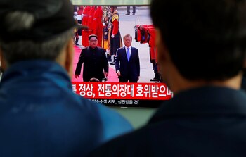 Dos hombre observan el encuentro en la estación de tren de Seúl. (REUTERS/Jorge Silva)