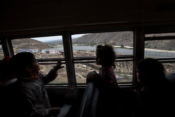 Niños observan el muro que