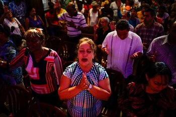 Personas rezan durante una ceremonia
