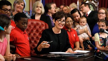 La gobernadora Kim Reynolds firma