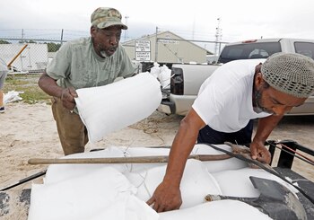Hombres llenan bolsas de arena