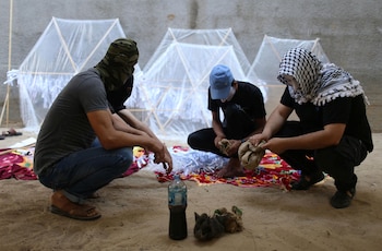 Tres palestinos empapan los trapos con combustible para luego encenderlos al lanzar las cometas (Reuters)