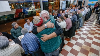 Oscar Luna (con gorra) abrazxando