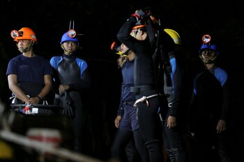 Un grupo de buzos recibe instrucciones en inmediaciones de la cueva (REUTERS/Athit Perawongmetha)