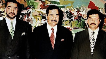 Saddam Hussein flanqueado por sus