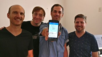 Figuerola (sosteniendo celular) con su equipo presentando la aplicación