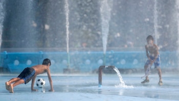 Los chicos combaten el calor jugando en el agua del Billie Jean King National Tennis Center