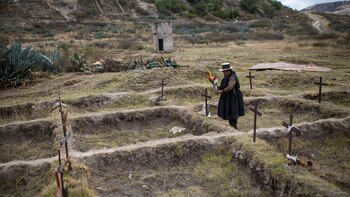 En esta foto del 16 de agosto de 2018, Lidia Flores coloca flores en La Hoyada, en el sitio donde cree que desapareció su esposo, Felipe Huaman Palomino, en Huamanga, Perú