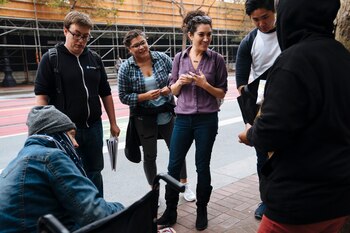 Jess Donig de Miracle Messages (centro) habla a dos mujers sin hogar en Market Street, en San Francisco (The Washington Post / Mason Trinca)