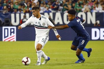 Víctor Guzmán, de México, y Weston McKennie, luchando por la pelota, en un partido de la Copa de Oro. (AFP)