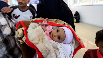 Una mujer yemení carga a