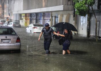 Dos personas cruzan una calle