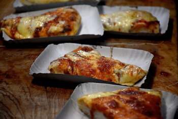 La pizza en porciones por