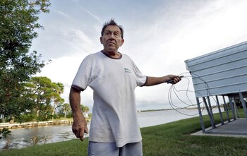 Robert Sandousky sostiene un cale para reparar su propiedad y dejarla lista para los fuertes vientos (AP)