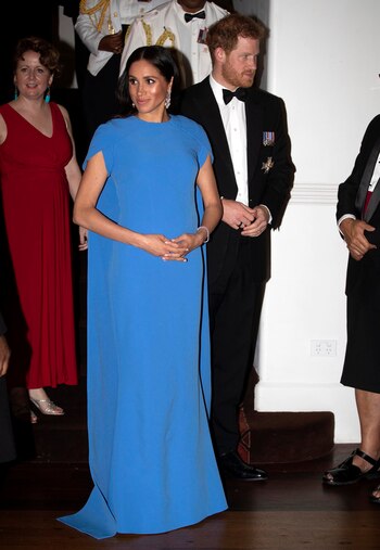 La duquesa de Sussex rindió homenaje a su país anfitrión cuando usó el vestido de ginkgo de Safiyaa en una cena de estado. El azul vibrante coincide con el tono que aparece en la bandera nacional de Fiji (AP Images)