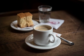 Pocillo de café y delicatessen de vainilla para acompañar la infusión de café