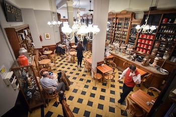 Desde la escalera de El Gato Negro. Piso cuadrillé en amarillo y negro, mesas y sillas de madera, un ícono del bar