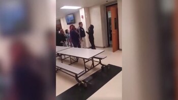 El docente, con pantalones blancos,