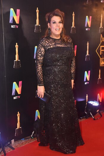 Costa con un diseños de Diego García Moyano en negro. Con mangas largas, transparencias y tul bordado. Combinó el outfit con aros y clutch negro