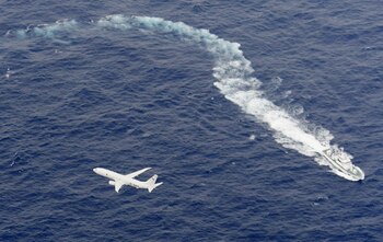 Un barco de la Guardia Costera japonesa y un avión de la Marina estadounidense durante las operaciones de búsqueda en la zona donde se produjo el accidente (Kyodo via REUTERS/archivo)