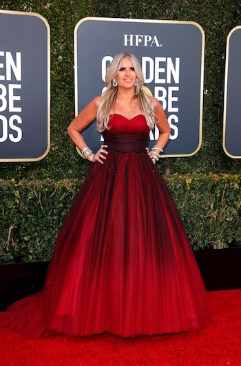 Tiziana Rocca enfundada en un vestido con diseño princesa de tul. Combinado con puntilla en negro y rojo con escote corazón. Completó su look con accesorios plateados, brazaletes, esclavas y aros colagantes